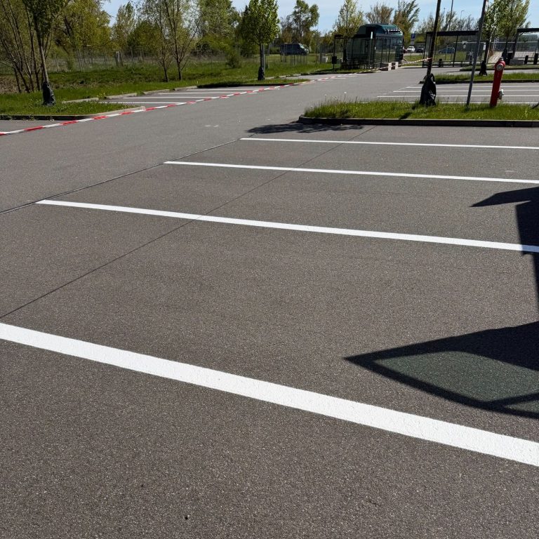 Stellplatzmarkierung eine graue Asphaltfläche mit weißen Markierungen