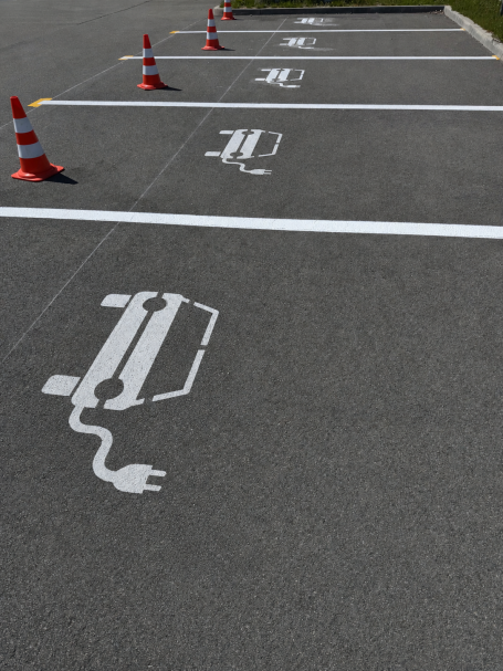 Parkplätze für Elektroautos, markiert mit entsprechenden Symbolen.