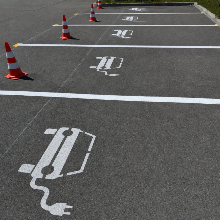 E-Parkplatz Ladestationen für Elektroautos auf einem Parkplatz, mit Absperrkegeln.