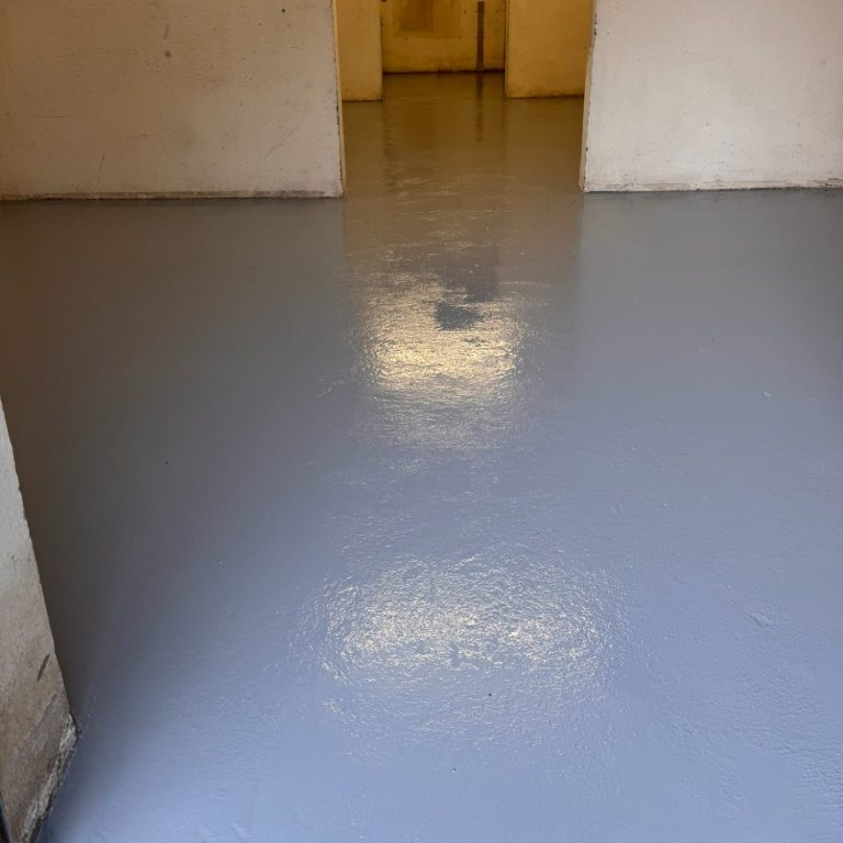 Der Boden ist grau und glänzend, in einem Raum mit Wänden und offenen Türen.