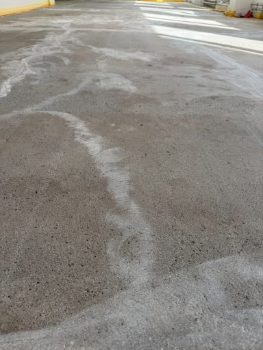 Eine graue, unebene Betonfläche mit weißen Schattierungen und Linien.