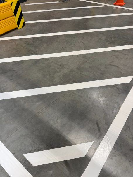 grauer Hallenboden mit einem weißen Sperrgatters