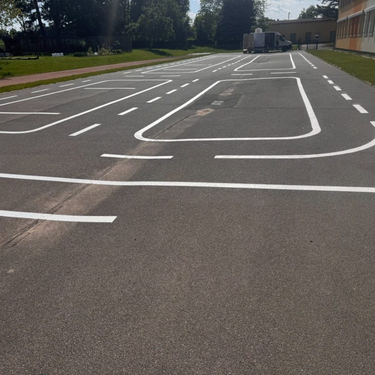 Leeres Übungsfeld mit mehreren weißen Linien für Verkehrsübungen.
