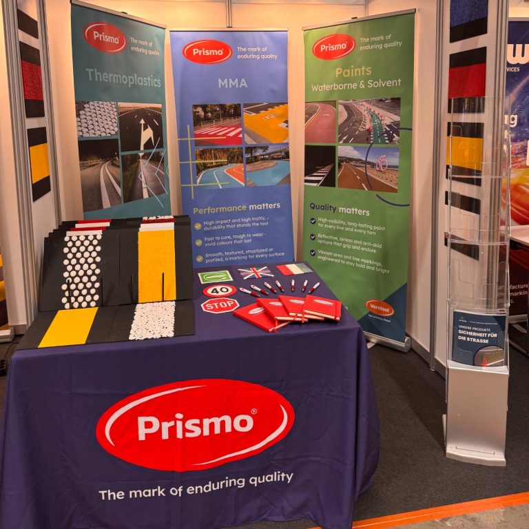 unser Prismo Messestand mit farbigen Werbebannern, ein Tisch mit Produktmustern