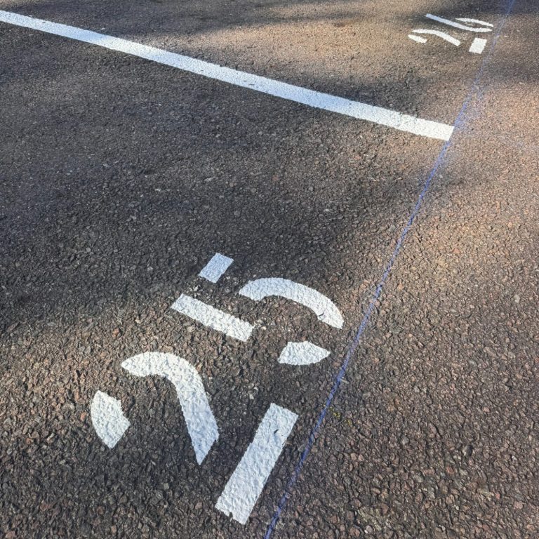 Nummerierungen Eine Asphaltfläche mit weißen Linien und einer weißen 25