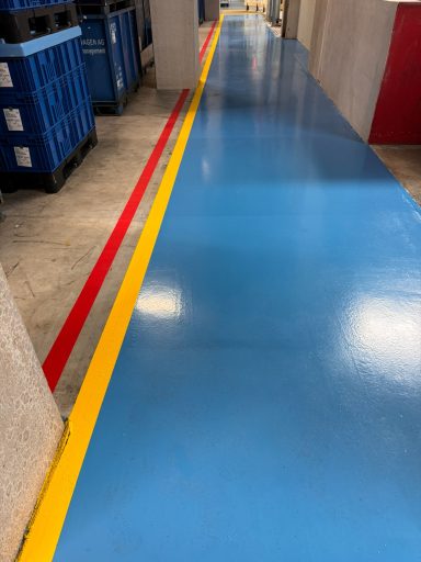 blau beschichteter Fußweg mit gelben und roten Linien an der linken Seite